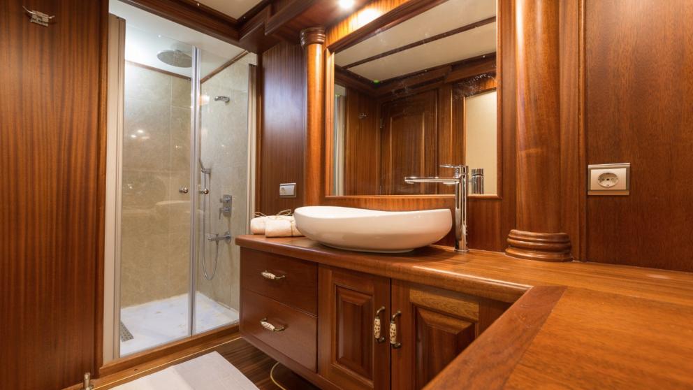 Halcon Del Mar's wooden gulet bathroom. You can see the shower cubicle and washbasin